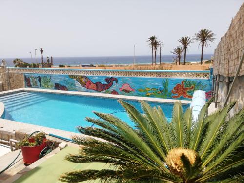 a large swimming pool with a mural on the side of a building at Almerimar Paraiso al Mar in Balerma