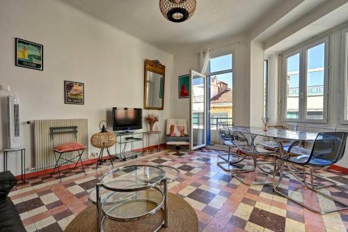 - un salon avec une table et des chaises en verre dans l'établissement Spacieux et lumineux, idéal T4 en centre ville, à Perpignan