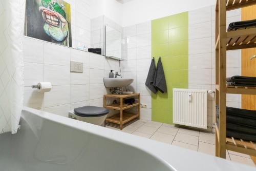 a bathroom with a tub and a toilet and a sink at 230 m2 Loft mit eigenem Wintergarten mit Tischtennis & Dart, kostenloser Parkplatz in Erfurt