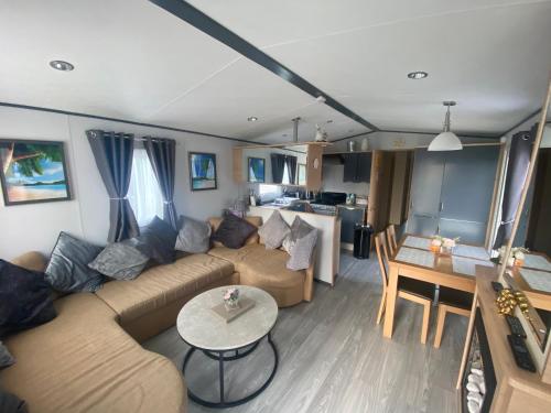 ein Wohnzimmer mit Sofa und Tisch in der Unterkunft Luxury Holiday Home Happiness at Tattershall lake# in Tattershall