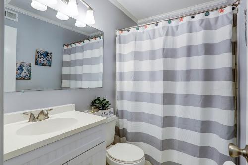 a bathroom with a sink and a shower curtain at Seaspray 134 in Atlantic Beach