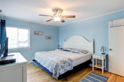 a blue bedroom with a bed and a ceiling fan at Seaspray 134 in Atlantic Beach