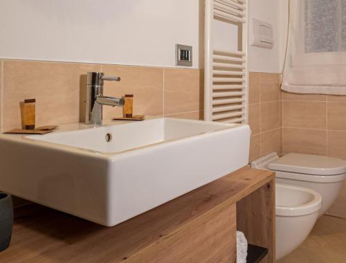 uma casa de banho com um lavatório branco e um WC. em Maison Blanche: appartamento elegante con parcheggio privato em Mantova