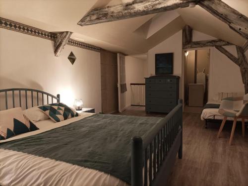 a bedroom with a large bed and a dresser in it at La Boussole - Maison meublée 3 chambres 6 pers. in Chinon