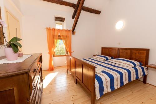 een slaapkamer met een bed, een dressoir en een raam bij Haus Gaia in Labin