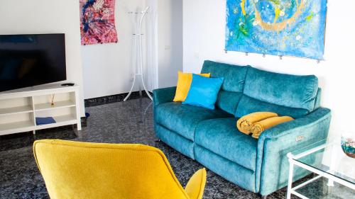 a living room with a blue couch and yellow chairs at Casa Sol y Mar in Garachico