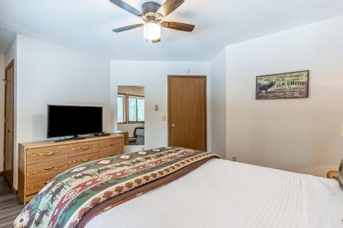 a bedroom with a bed and a flat screen tv at Ptarmigan's Roost in Whitefish
