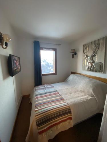 une chambre avec un grand lit et une fenêtre dans l'établissement Agréable appart 4Pers, Gd balcon, vue panoramique garage et wi-fi, à Orcières