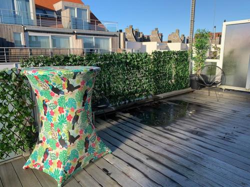 une terrasse en bois avec un parasol sur le balcon dans l'établissement Beautiful penthouse at 5min of Albert place, à Knokke-Heist