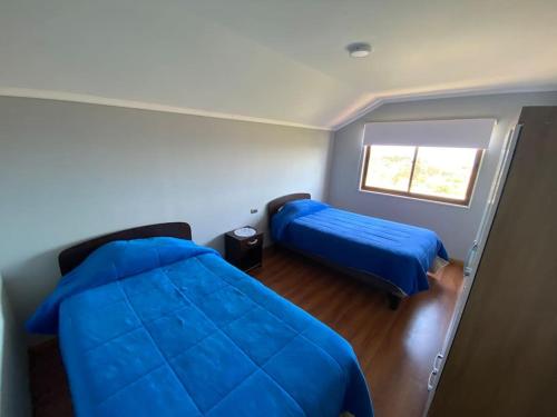 a bedroom with two beds and a window at Departamento N con hermosa vista al mar in Los Vilos
