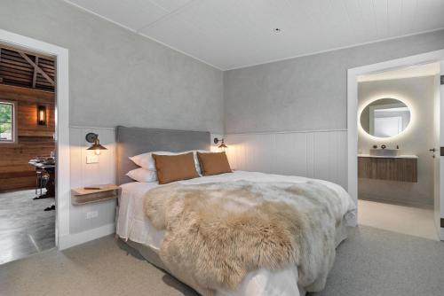 a bedroom with a large bed with a furry blanket at Historical Hicks Cottage in Queenstown