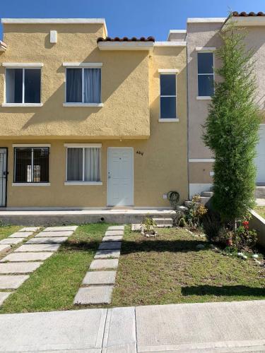 una casa con un árbol delante de ella en Borrallas en Puebla