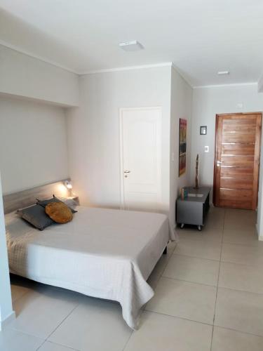 a bedroom with a large bed and a wooden door at Apart del Centro 02 cochera opcional in Santa Fe