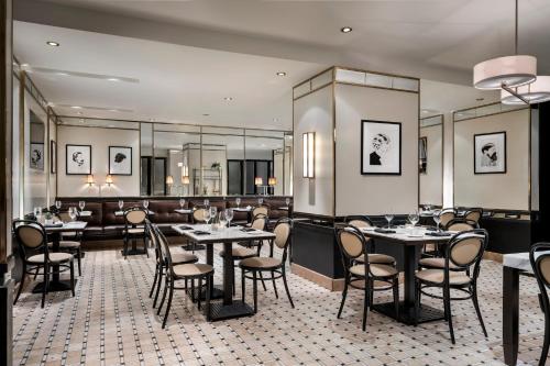 a restaurant with tables and chairs and a bar at Omni Mont-Royal Hotel in Montreal