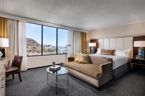 モントリオールにあるオムニ モン-ロイヤル ホテルのベッドとソファ付きのホテルルーム