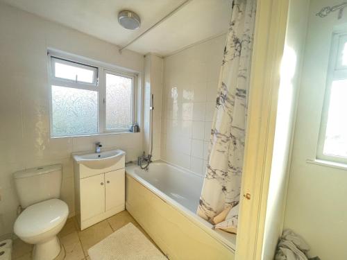 uma casa de banho com um WC, uma banheira e um lavatório. em Comfy Letchworth Apartment by Leecroft Stays em Letchworth
