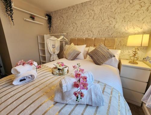 a bedroom with a bed with towels and flowers on it at Home from Home Slough in Slough