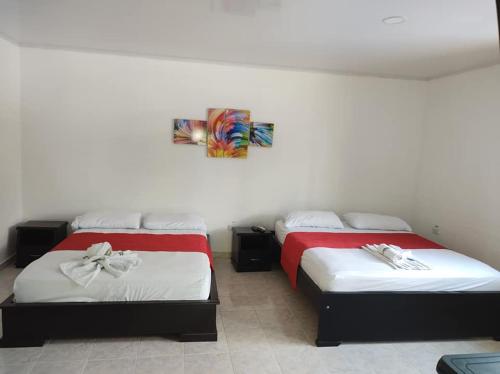 dos camas sentadas una al lado de la otra en una habitación en Hotel Campo Verde en Villagarzón