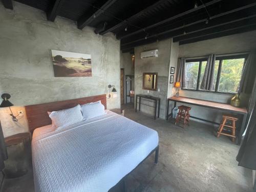 a bedroom with a bed and a desk in it at San Carlos Surf Resort & Eco Lodge in San Carlos