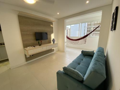 sala de estar con sofá azul y TV en Apartamento em Torres-906 - Uma quadra do mar, en Torres