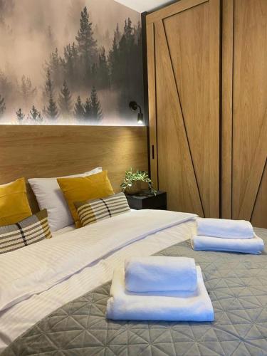 a large bed with two pillows on top of it at REST4U APARTAMENTY z SAUNAMI in Szczyrk