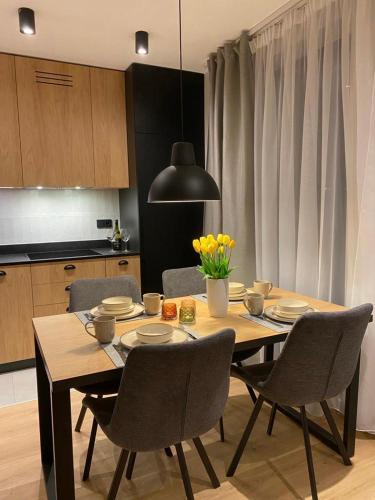 a dining room table and chairs in a kitchen at REST4U APARTAMENTY z SAUNAMI in Szczyrk