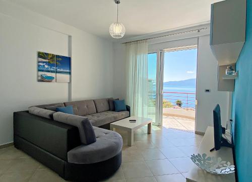 a living room with a couch and a tv at Sunny Apts in Sarandë