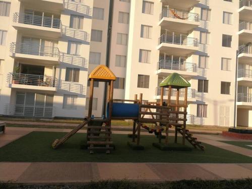 two playground equipment in front of a building at Apartamento vista a la montaña in Girardot