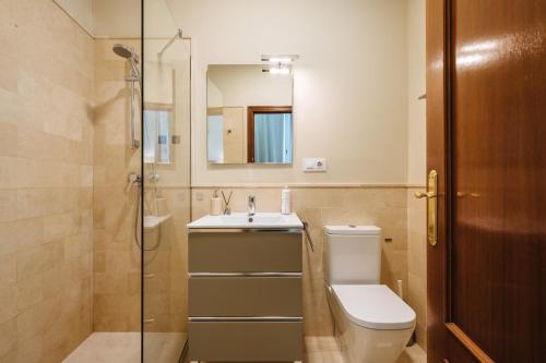 a bathroom with a toilet and a sink and a mirror at HomeySeville-Amazing Views Cathedral Tomas de Ibarra - 8 pax, Parking Optional in Seville