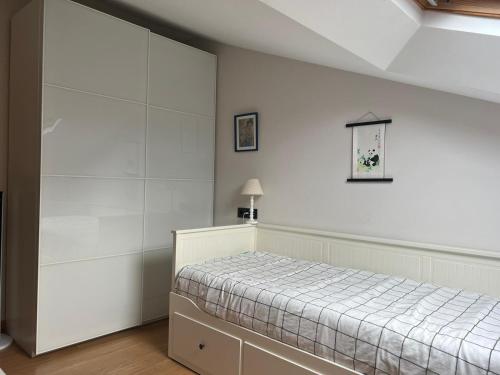 a bedroom with a bed and a white wall at Kobentu Berri by Smiling Rentals in Hondarribia