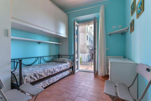 濱海里約的住宿－Appartamento per 4 sul mare a Rio Marina, Elba，一间设有床铺的卧室,位于一间拥有蓝色墙壁的房间
