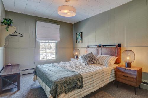 a bedroom with a bed and two lamps and a window at Auberge des Cantons in Magog-Orford