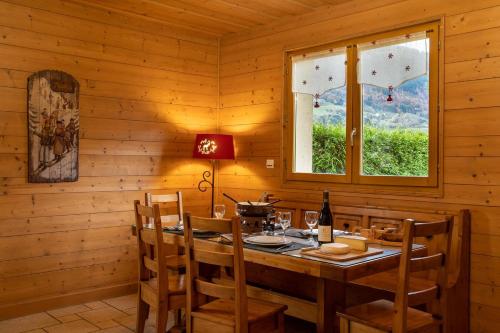 a dining room with a table and a window at GITE BALNEO LES AMARYLLIS in Taninges