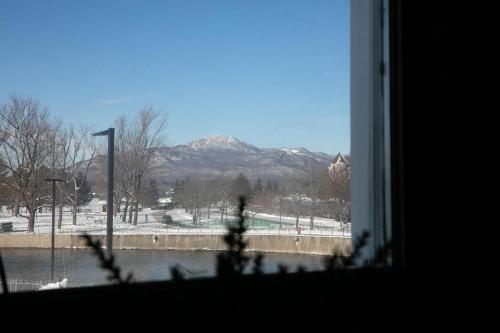 a view of a snowy mountain from a window at Auberge des Cantons in Magog-Orford