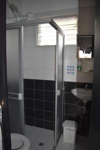 y baño con ducha, aseo y lavamanos. en Esmed Hostel, en Medellín