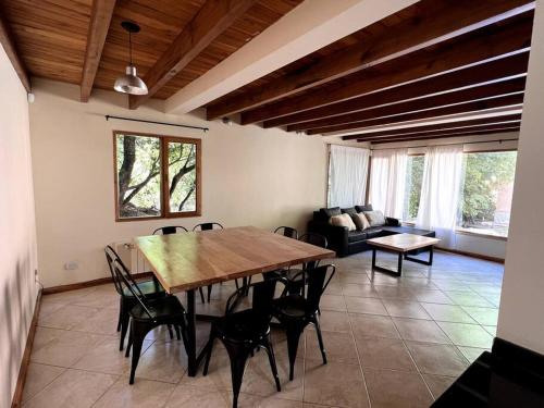sala de estar con mesa de madera y sillas en Casa en San Martin de Los Andes en San Martín de los Andes