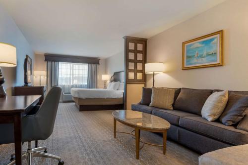 a living room with a couch and a bed at Best Western PLUS Vineyard Inn and Suites in Penn Yan