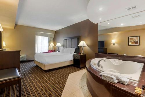 a hotel room with a bed and a bath tub at Best Western Plus Burlington Inn & Suites in Burlington