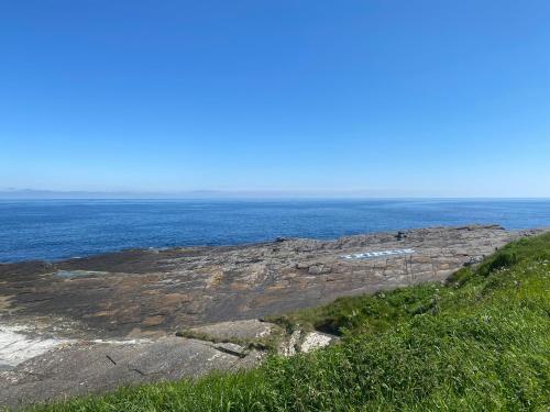 vista sull'oceano da una collina con erba di Farr North Lodge 1 a Wick