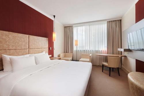 um quarto de hotel com uma cama grande e uma mesa em Radisson Blu Szczecin em Szczecin