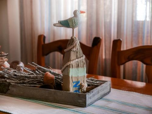 um pássaro de madeira sentado em cima de uma mesa em Villa Ricardo em Fornes