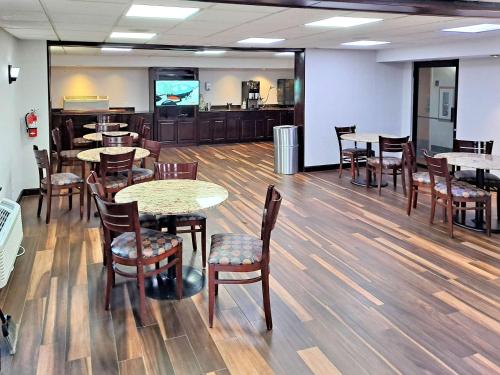 a dining room with tables and chairs and a television at Motel 6 Catonsville MD Baltimore West in Catonsville