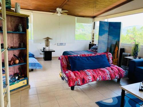 a living room with a red couch and a bed at El Cielo en la laguna. in Santa María del Oro