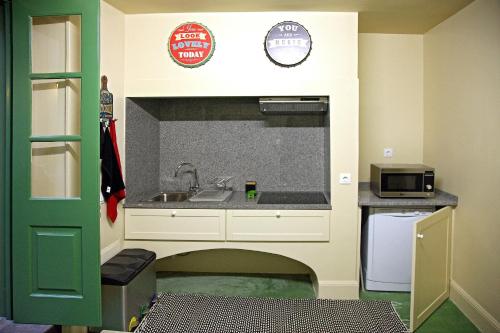 a small kitchen with a sink and a microwave at 29 Madeira Hostel in Funchal