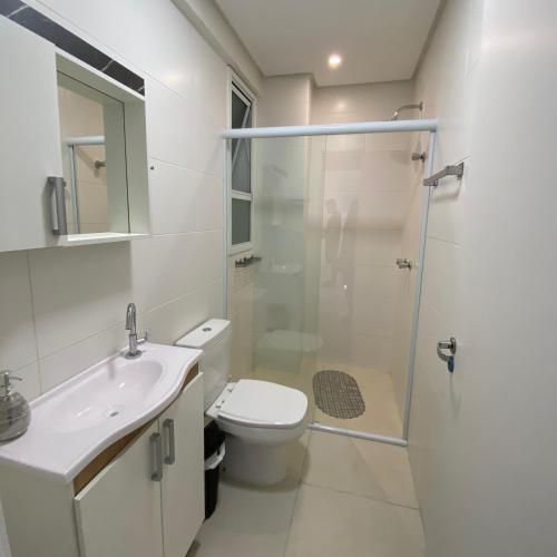 a bathroom with a toilet and a sink and a shower at Apartamento em Torres 2 quartos centro 1 quadra do mar - 906 in Torres