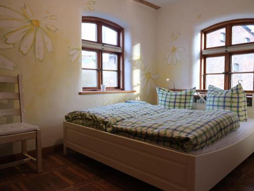 a bedroom with a bed in a room with windows at Idyllic Apartment in Carinerland near Baltic Sea in Neu Karin