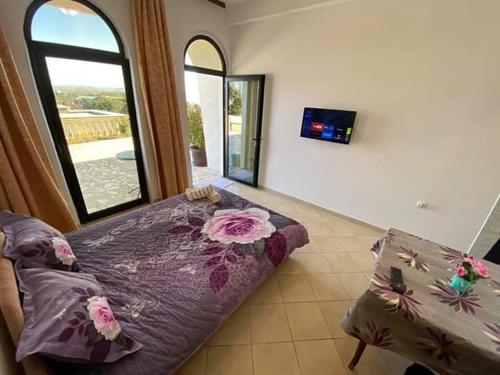 um quarto com uma cama, uma televisão e uma janela em Apartments Plaza em Ulcinj