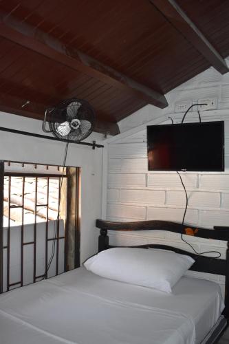 a bedroom with a bed and a flat screen tv at Esmed Hostel in Medellín