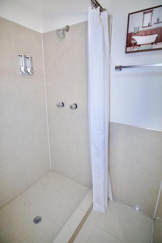 a bathroom with a shower with a glass door at Rio Suites in Tijuana