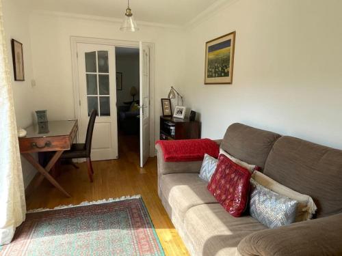 sala de estar con sofá, mesa y escritorio en Braunton Breaks - Ambrose Cottage, en Braunton